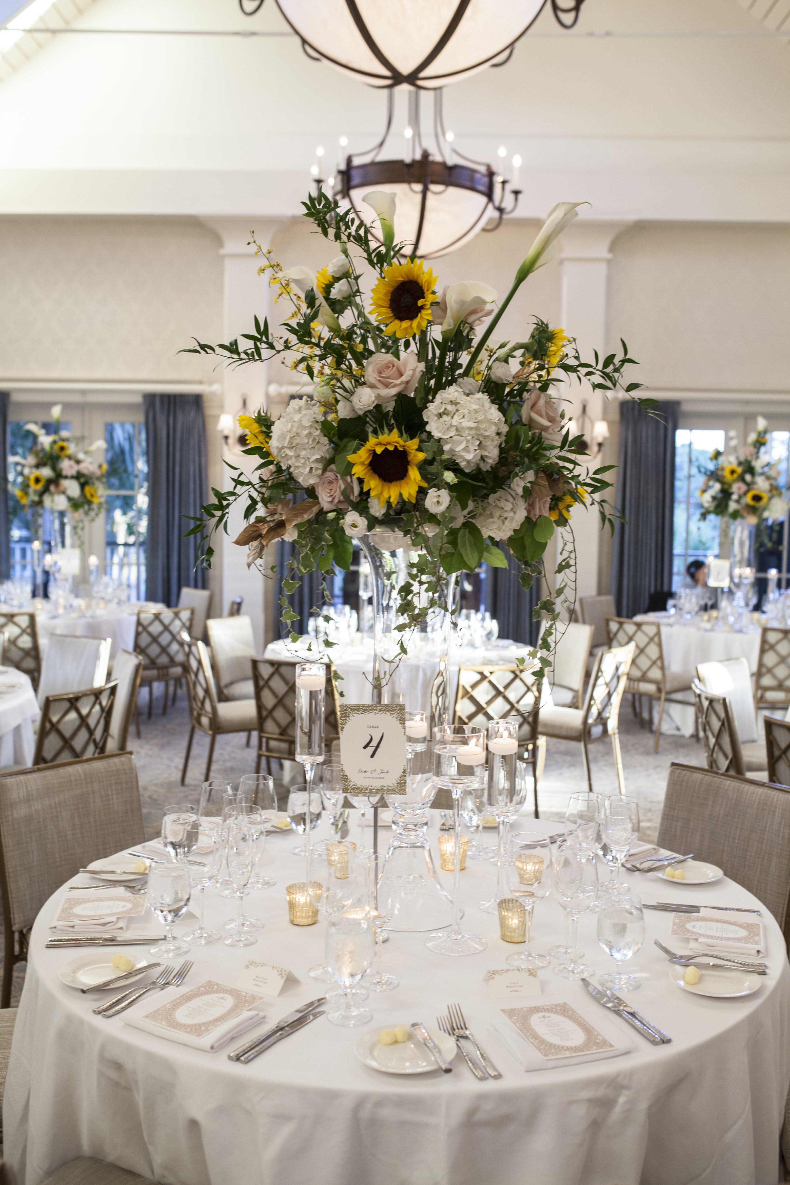 Fine art wedding details including custom place settings and lush floral arrangements